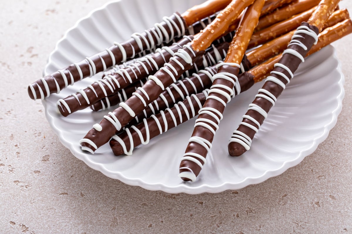 Chocolate dipped pretzel rods with dark and white chocolate drizzle